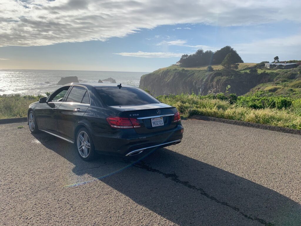 Black Sedan In a Parking by Ocean